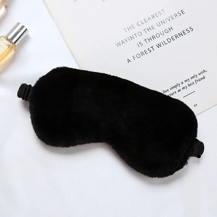 Maschera per dormire in pelliccia sintetica nera su sfondo bianco, accessorio per il sonno, comfort notturno, relax, ideale per viaggi e riposo.