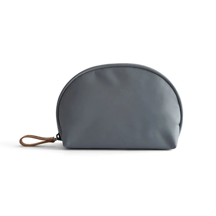 Borsa cosmetica grigia in pelle sintetica, design a mezzaluna, con cerniera e manico in pelle marrone. Accessorio elegante e pratico per viaggio.