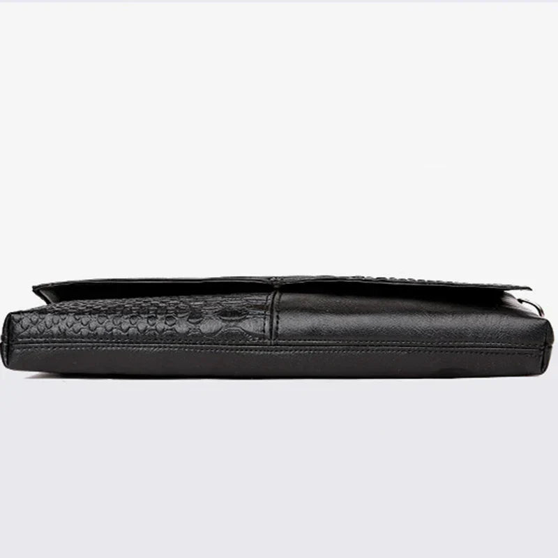 Elegante borsa a tracolla in pelle nera con texture a coccodrillo, design sottile e moderno, ideale per uomo d'affari. Accessorio di lusso.