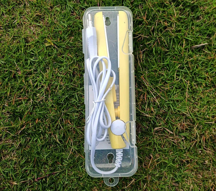 Custodia trasparente con termometro digitale giallo e cavo bianco su erba verde. Accessorio medico portatile, misurazione temperatura precisa.