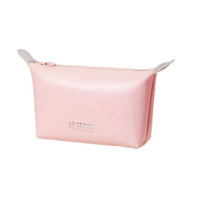 Astuccio cosmetico rosa in pelle sintetica con cerniera, design minimalista, ideale per trucchi e accessori da viaggio.