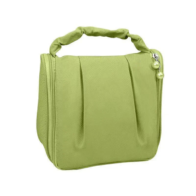Borsa cosmetica verde chiaro con manico intrecciato, design elegante e chiusura a zip. Ideale per viaggi, organizzazione trucco e accessori.
