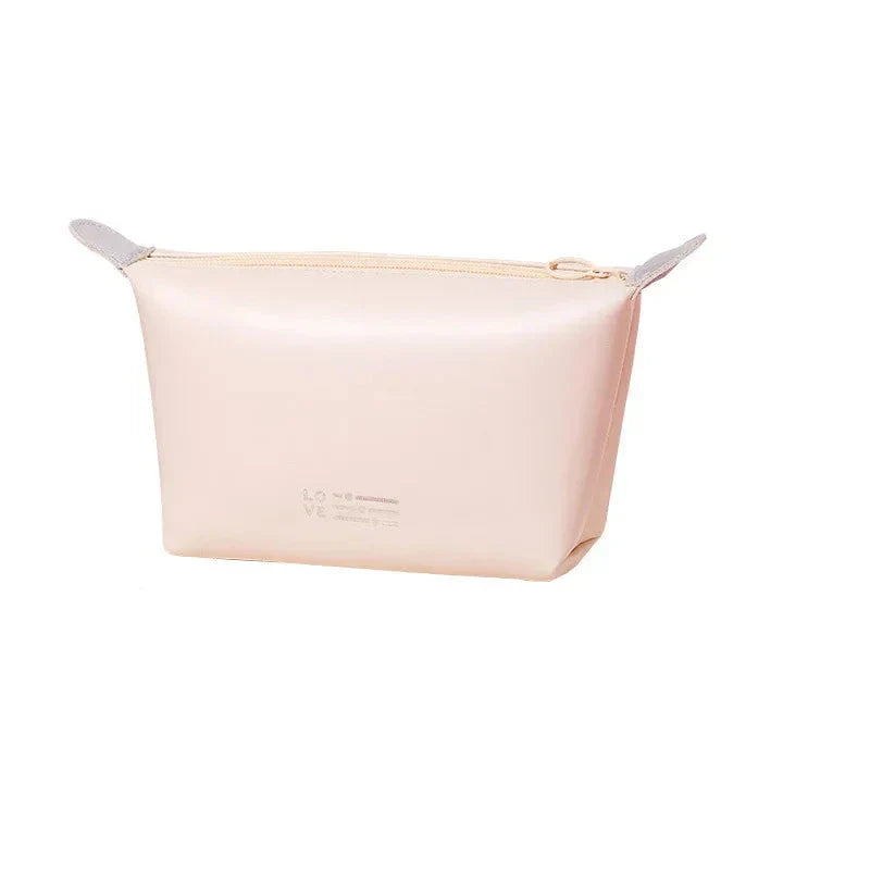 Astuccio cosmetico beige in silicone, design minimalista, chiusura con zip, ideale per organizzare trucchi e accessori da viaggio.