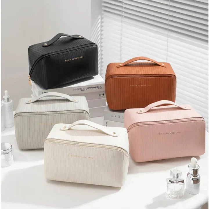 Set di cinque eleganti beauty case in ecopelle, colori assortiti, con manico e zip, ideali per cosmetici e accessori da viaggio.