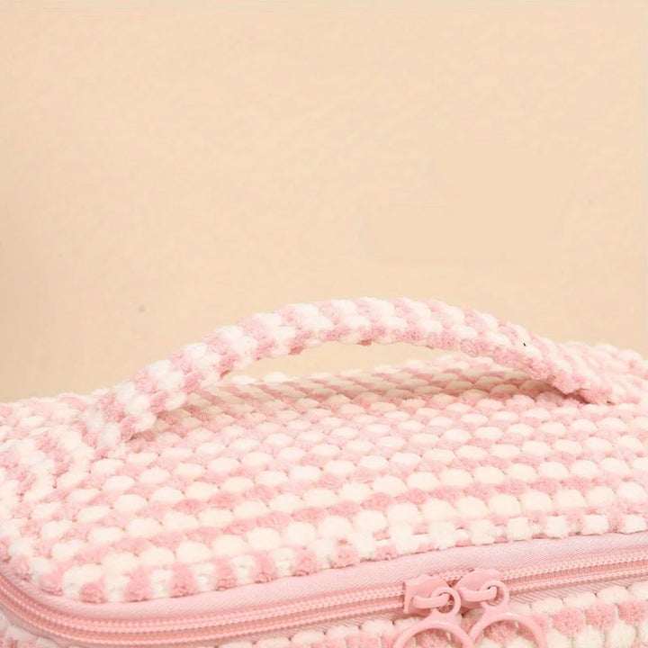 Borsa cosmetica rosa in tessuto a maglia con manico, chiusura a zip, design elegante e morbido, ideale per viaggi e organizzazione trucco.