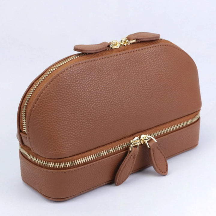 Borsa cosmetica in pelle marrone con doppia cerniera dorata, design elegante e compatto, ideale per organizzare trucchi e accessori da viaggio.