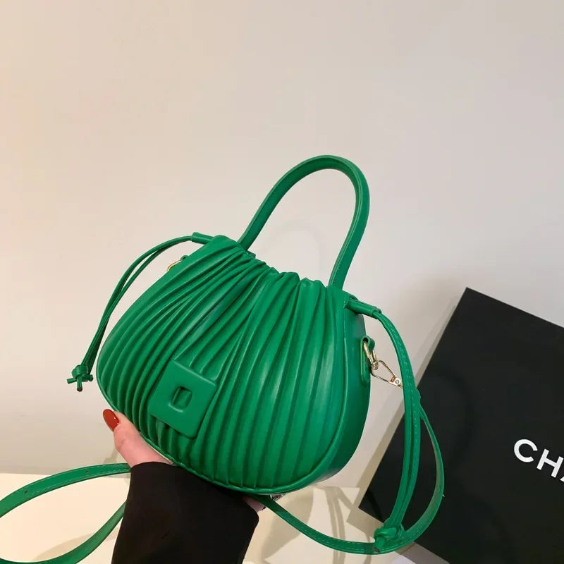 Borsa a mano verde in pelle con design plissettato, manici arrotondati e tracolla regolabile. Elegante accessorio moda per donna.