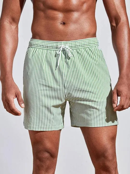 Costume da bagno uomo a righe verdi e bianche, con laccio in vita. Design moderno, ideale per la spiaggia e il nuoto. Tessuto leggero e confortevole.