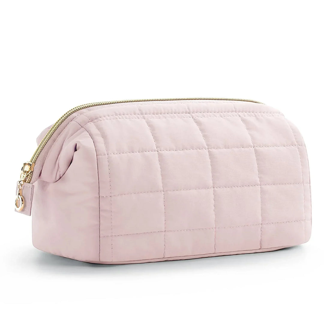 Astuccio da toilette trapuntato rosa chiaro con cerniera dorata, design elegante e spazioso, ideale per viaggi e organizzazione cosmetici.
