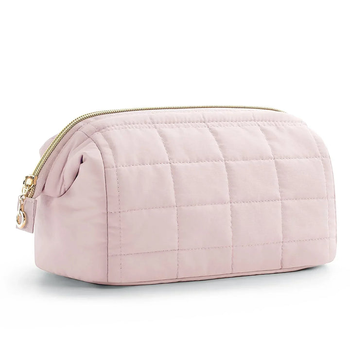 Astuccio da toilette trapuntato rosa chiaro con cerniera dorata, design elegante e spazioso, ideale per viaggi e organizzazione cosmetici.