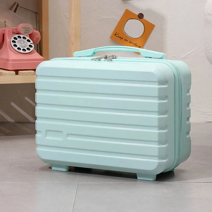Valigia rigida azzurra su pavimento grigio, design moderno, vicino a telefono vintage rosa. Accessorio da viaggio elegante e funzionale.