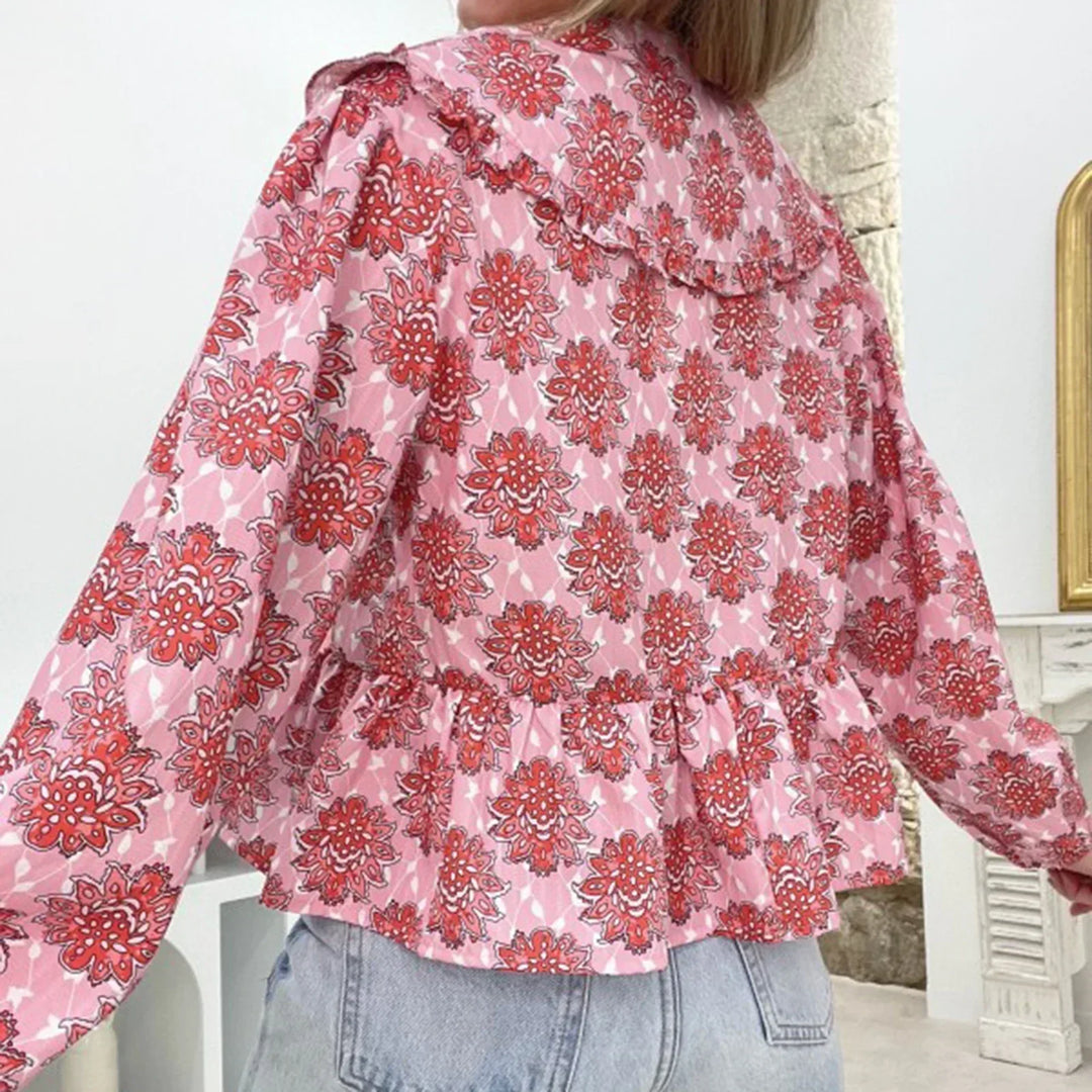 Blusa donna floreale rosa e rossa, maniche lunghe, colletto ampio, abbinata a jeans chiari. Moda femminile, abbigliamento casual elegante.