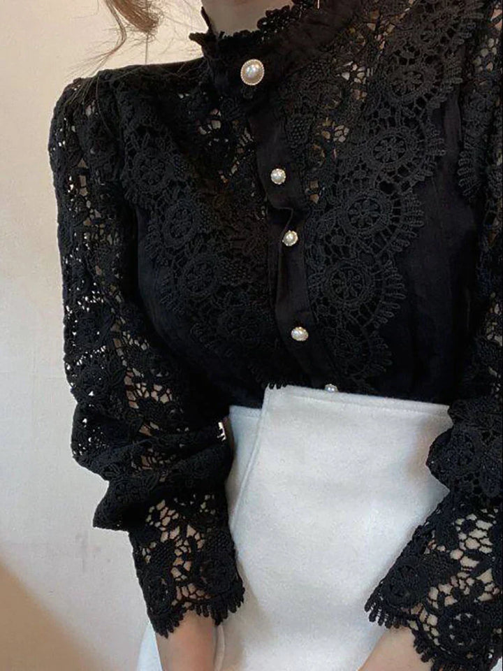 Blusa nera in pizzo con bottoni perla, maniche lunghe, elegante e raffinata, perfetta per occasioni formali e moda donna autunno inverno.