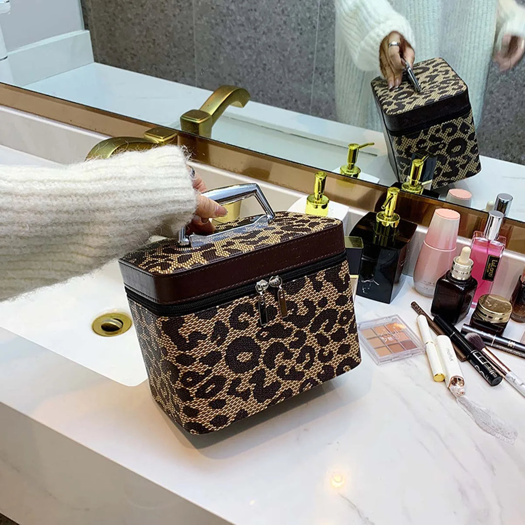 Borsa cosmetica leopardata su lavabo bagno, con cerniera e manico, accanto a trucchi e profumi. Design elegante, accessorio moda essenziale.