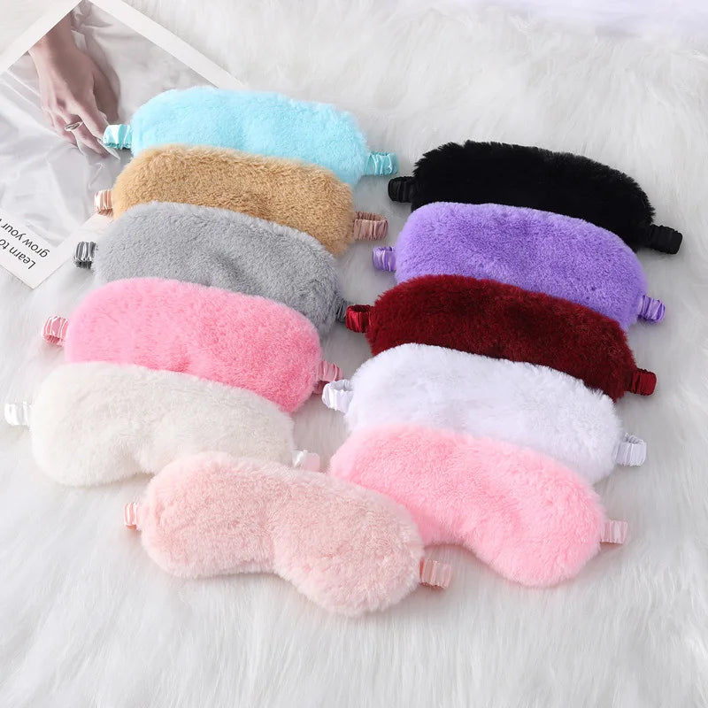 Mascherine per dormire in peluche multicolore su sfondo bianco. Accessori per il sonno morbidi e confortevoli, ideali per relax e riposo.