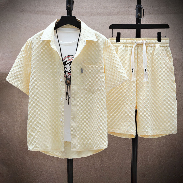 Set coordinato estivo uomo in tessuto a nido d'ape beige, composto da camicia a maniche corte e pantaloncini con coulisse, stile casual e moderno.