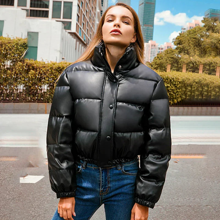 Giacca invernale nera imbottita da donna, stile casual, indossata all'aperto. Perfetta per moda urbana e protezione dal freddo.