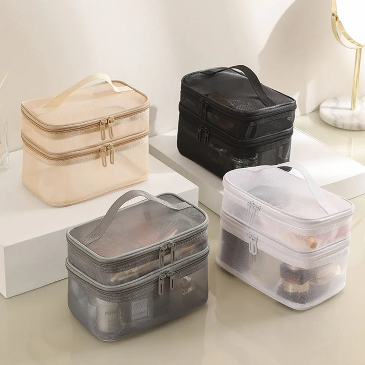 Quattro beauty case trasparenti e opachi in vari colori su un tavolo, ideali per organizzare cosmetici e accessori da viaggio.