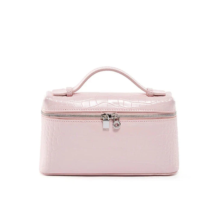 Borsa cosmetica rosa in pelle sintetica con texture coccodrillo, chiusura a zip e manico superiore. Elegante e pratica per viaggi e organizzazione.