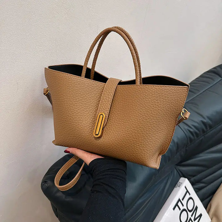 Borsa a mano in pelle marrone, design elegante, chiusura a bottone, manici doppi, ideale per moda donna, accessorio di tendenza.