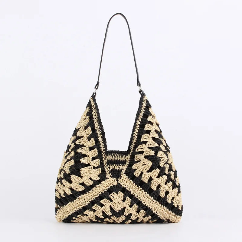 Borsa a spalla in paglia intrecciata nera e beige, design geometrico, manico sottile. Perfetta per look estivi e casual.