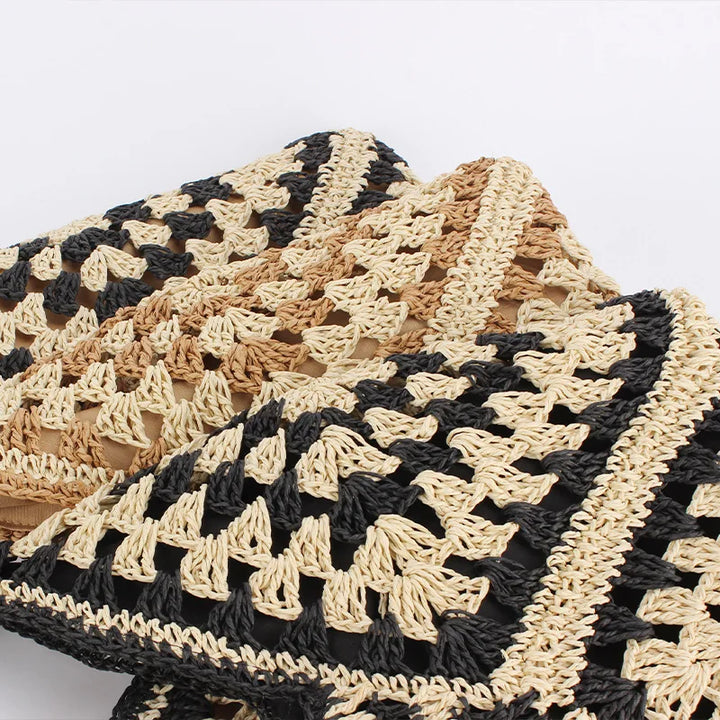 Cuscino decorativo in maglia crochet beige e nero, design geometrico, stile boho chic, ideale per arredamento soggiorno o camera da letto.