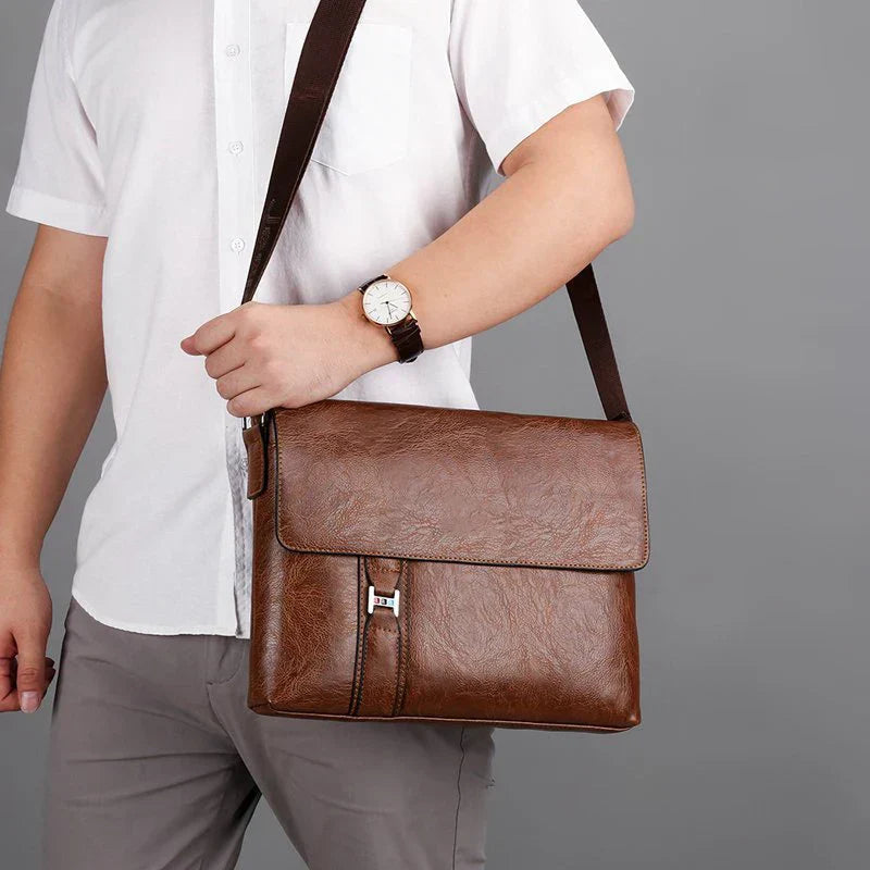 Uomo con camicia bianca indossa borsa a tracolla in pelle marrone, elegante e pratica, ideale per lavoro e ufficio. Accessorio moda maschile.