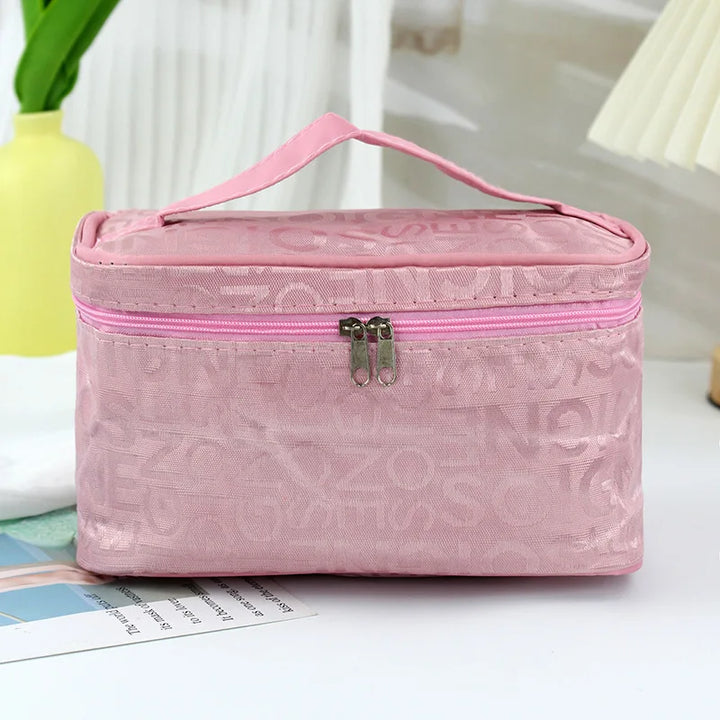 Borsa cosmetica rosa con cerniera, manico superiore, design elegante, ideale per organizzare trucchi e accessori da viaggio.
