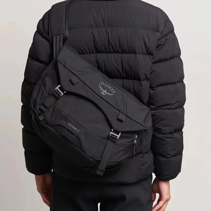 Zaino nero Osprey Metron 22L indossato su giacca imbottita, design urbano, resistente e spazioso, ideale per viaggi e uso quotidiano.
