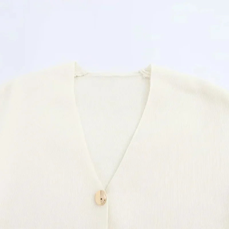 Cardigan beige in maglia a coste con scollo a V e bottone singolo. Elegante e versatile, ideale per look casual e formali.