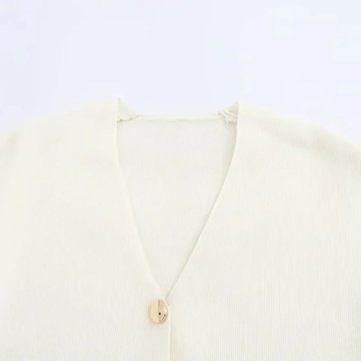 Cardigan beige in maglia a coste con scollo a V e bottone singolo. Elegante e versatile, ideale per look casual e formali.