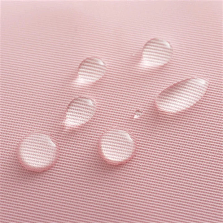 Gocce d'acqua su tessuto impermeabile rosa, texture a righe. Materiale resistente all'acqua, ideale per abbigliamento outdoor e accessori.