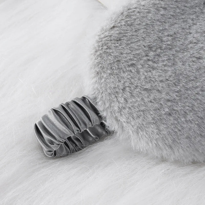 Cuscino grigio in pelliccia sintetica con manico elastico, design elegante e morbido, ideale per decorazione casa e comfort.
