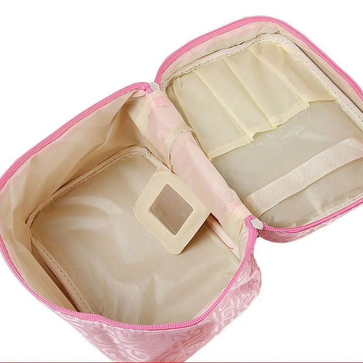 Astuccio cosmetico rosa aperto, con scomparti interni beige e specchietto. Ideale per organizzare trucchi e accessori da viaggio.