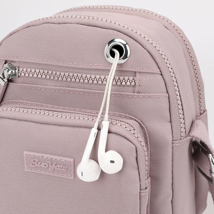 Zaino rosa con tasca frontale, cerniera argentata e auricolari bianchi inseriti. Design moderno, ideale per scuola e viaggio.