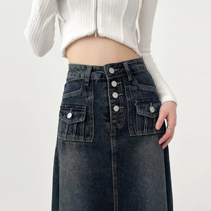 Gonna lunga in denim nero con bottoni, tasche frontali, abbinata a top bianco a coste. Moda casual donna, abbigliamento trendy autunno.