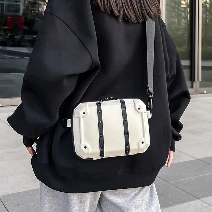 Zaino bianco rigido con cinghie nere indossato da una persona in abbigliamento casual. Design moderno, ideale per moda urbana e viaggi.
