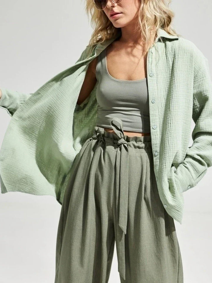 Donna con camicia verde chiaro in cotone, top corto e pantaloni a vita alta. Moda casual estiva, abbigliamento femminile trendy.