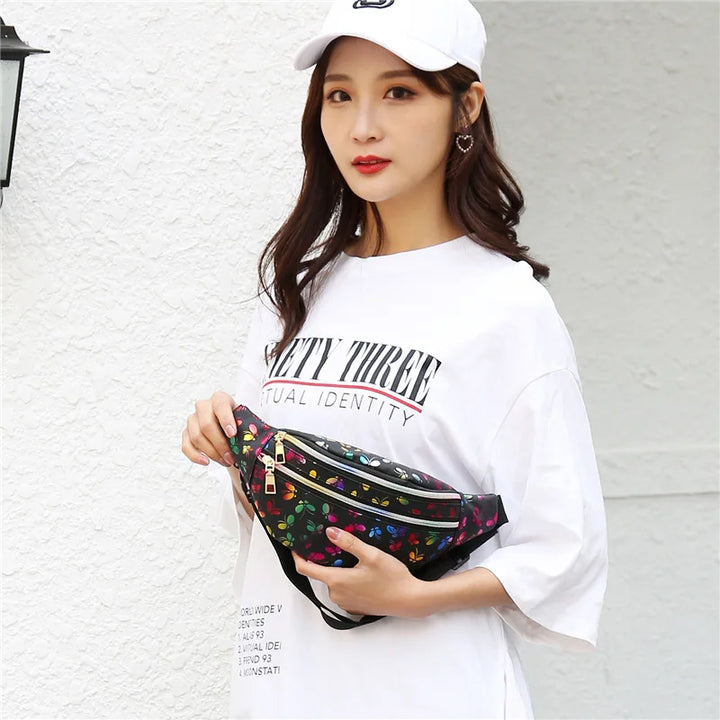 Giovane donna con cappellino bianco e maglietta oversize, indossa marsupio nero floreale. Moda casual, accessori trendy, street style femminile.