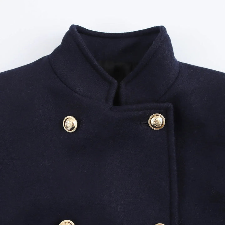 Cappotto blu scuro in lana con colletto alto e bottoni dorati, stile militare elegante, moda uomo autunno inverno, abbigliamento formale.