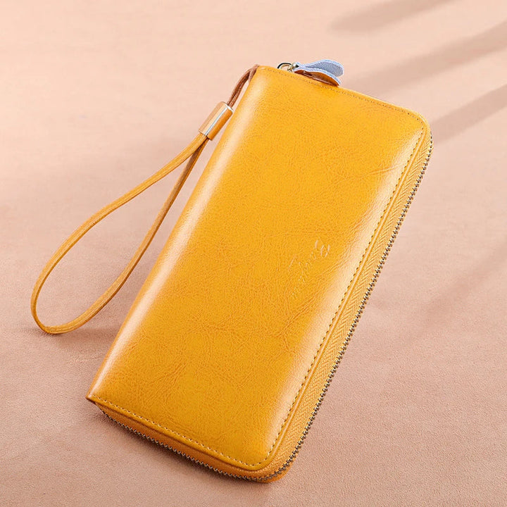 Portafoglio donna in pelle gialla con cerniera e cinturino da polso, design elegante e moderno, accessorio moda essenziale.