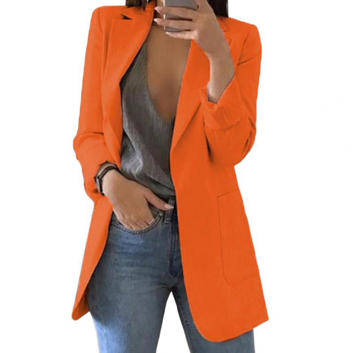 Giacca arancione da donna, elegante e moderna, abbinata a top grigio e jeans. Moda femminile, abbigliamento casual chic, tendenze 2023.