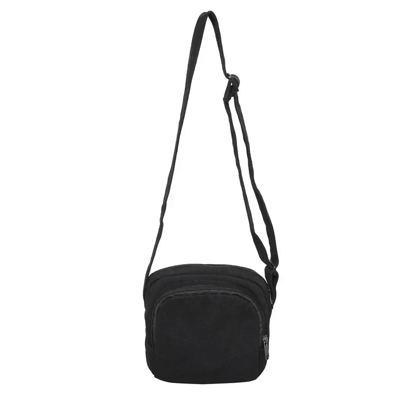 Borsa a tracolla nera in tessuto, design compatto con cerniera, ideale per uomo e donna. Accessorio moda pratico e versatile.