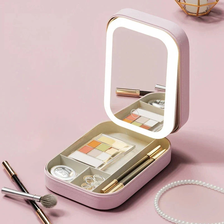 Specchiera portatile rosa con luci LED, scomparti per trucchi, pennelli e gioielli. Design compatto, ideale per viaggi e organizzazione cosmetici.