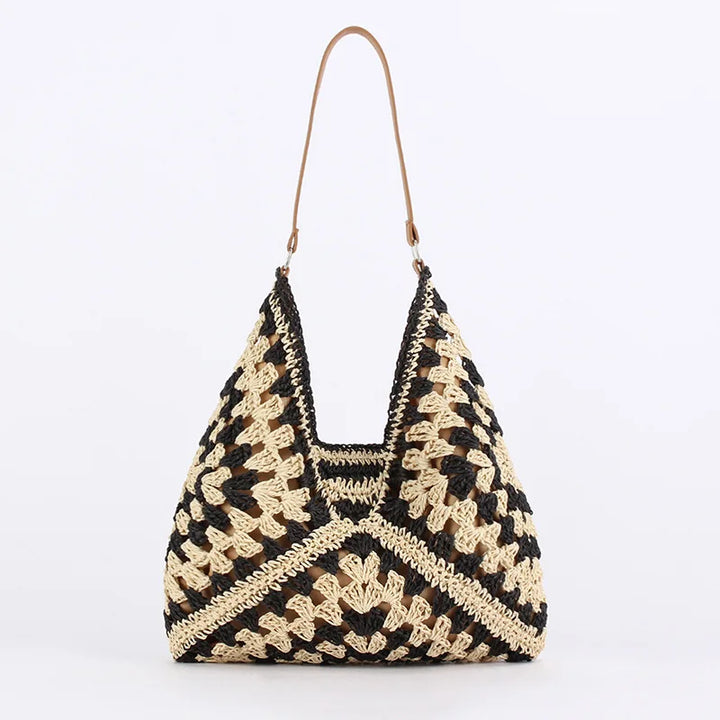 Borsa a spalla in paglia intrecciata, design geometrico nero e beige, manico in pelle. Perfetta per l'estate e lo stile boho chic.