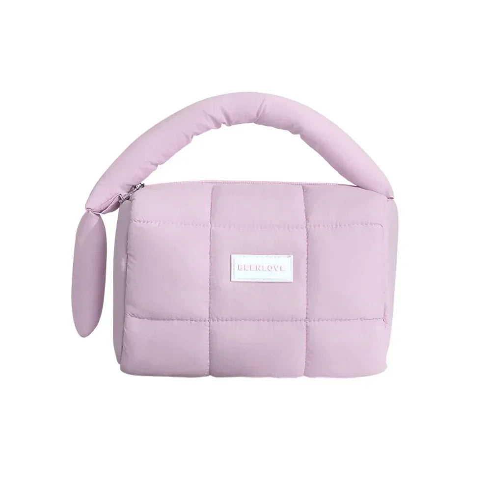 Borsa a mano trapuntata rosa pastello, design moderno, manico imbottito, ideale per moda femminile. Accessorio elegante e versatile.