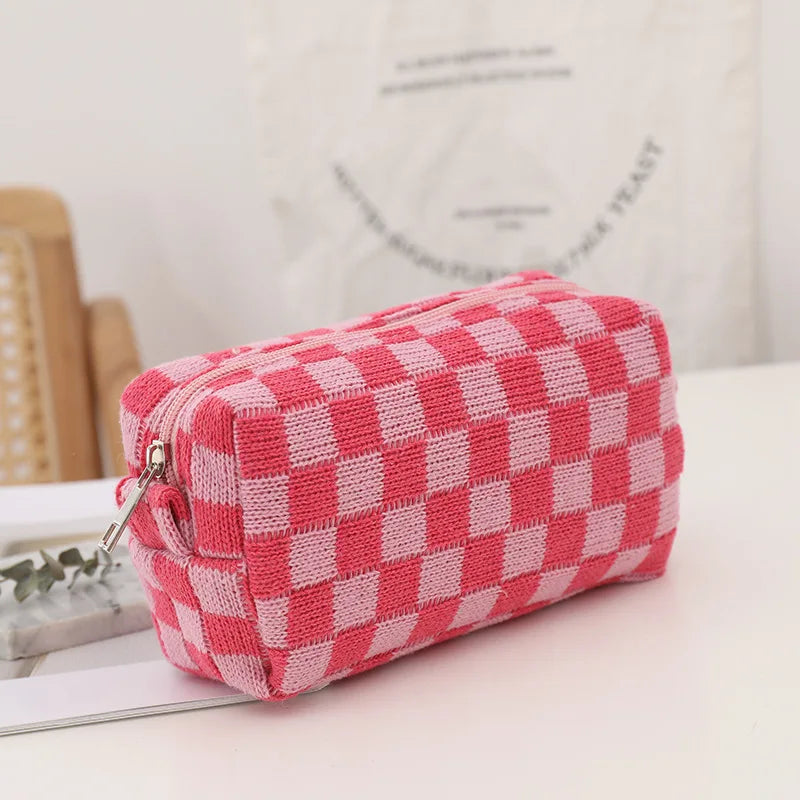 Astuccio a scacchi rosa e bianco, tessuto morbido, chiusura con cerniera, ideale per scuola o ufficio, design moderno e funzionale.