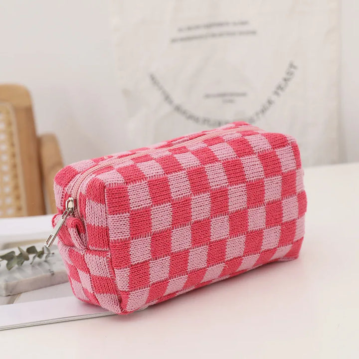 Astuccio a scacchi rosa e bianco, tessuto morbido, chiusura con cerniera, ideale per scuola o ufficio, design moderno e funzionale.
