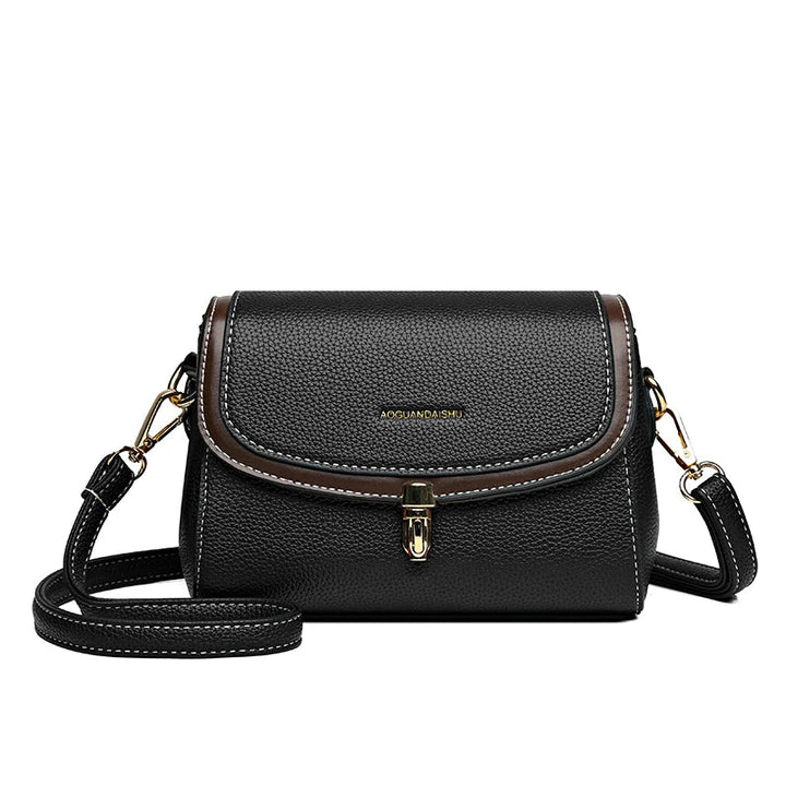 Borsa a tracolla in pelle nera con dettagli marroni, chiusura a fibbia dorata e tracolla regolabile. Elegante accessorio moda donna.