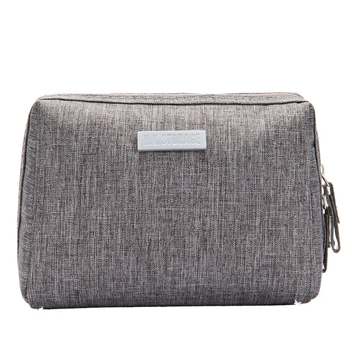Astuccio grigio in tessuto con cerniera, design rettangolare, ideale per scuola o ufficio. Accessorio pratico e resistente per organizzare penne e matite.